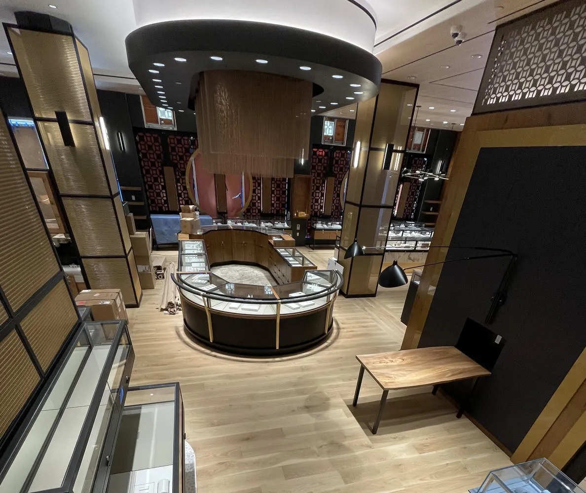 Empty jewelry display cases arranged in a U-shape with wooden flooring in a retail store