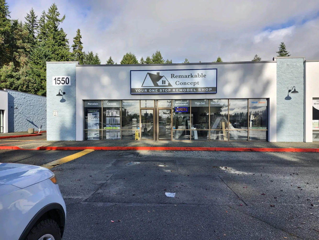 A one-story building with a sign that reads "Remarkable Concept, Your One Stop Remodel Shop" over the entrance.